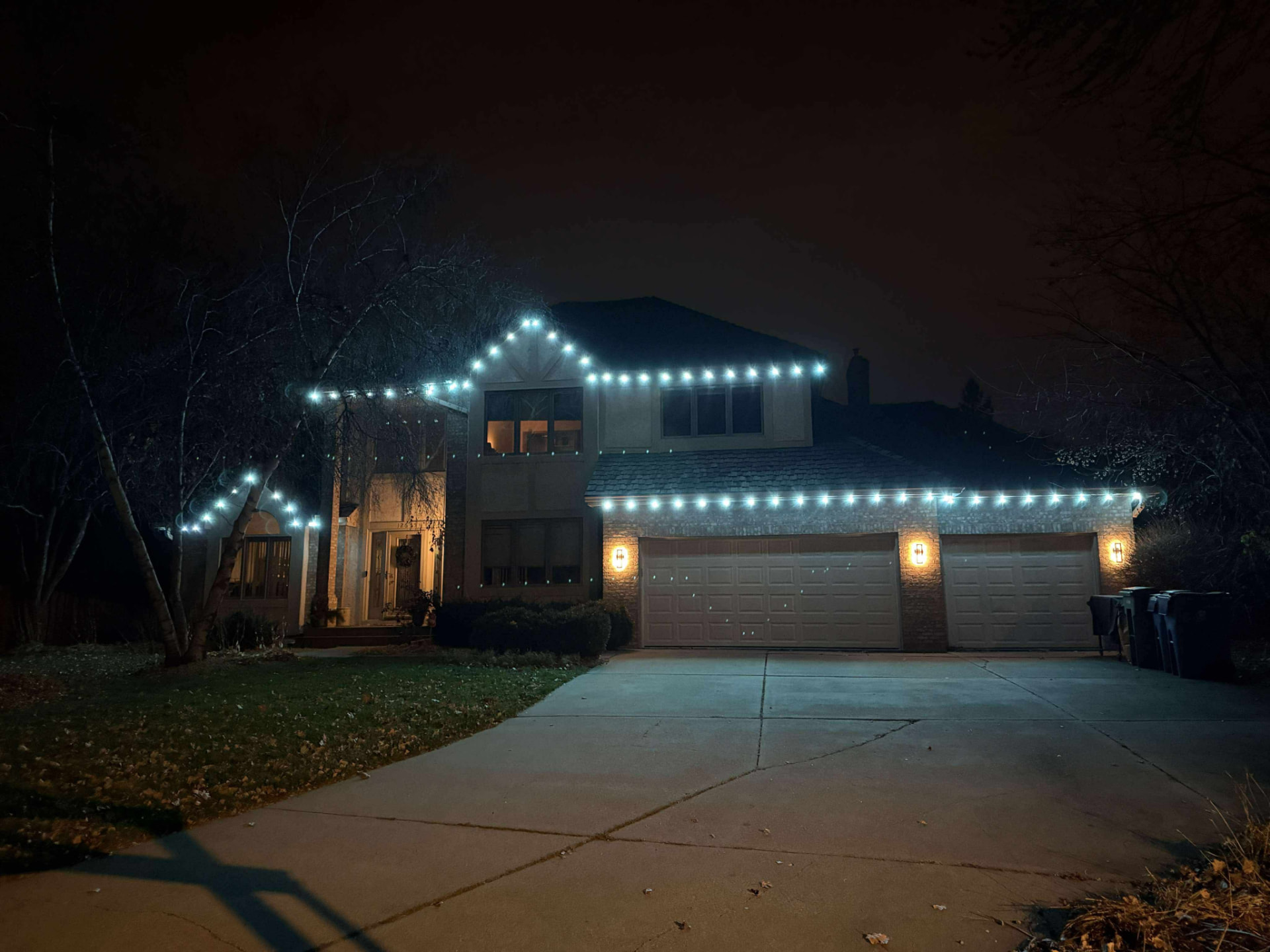 Brick home with crisp white permanent LED lights along the roofline