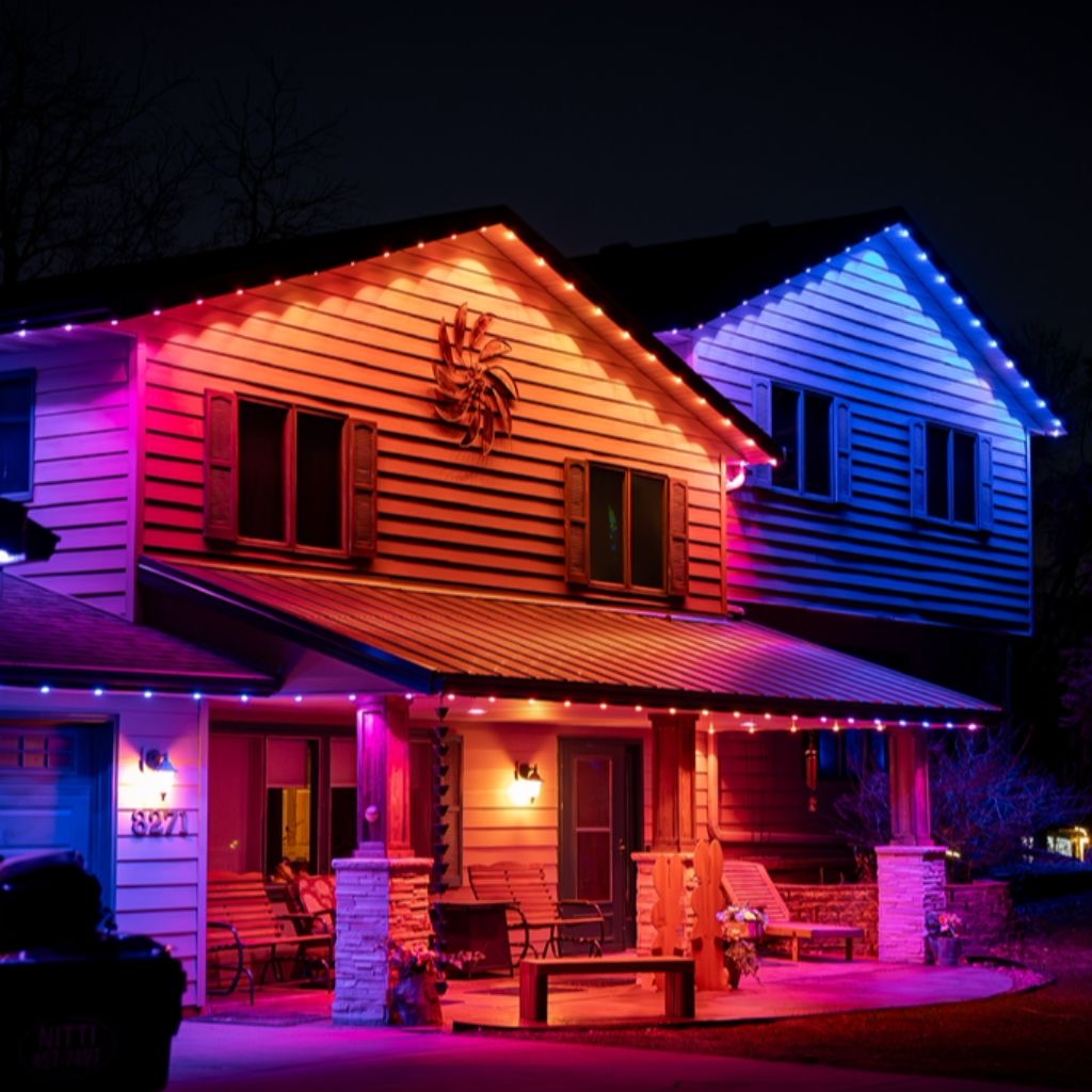 Two-story home outlined in red, blue and pink permanent LED lighting at night