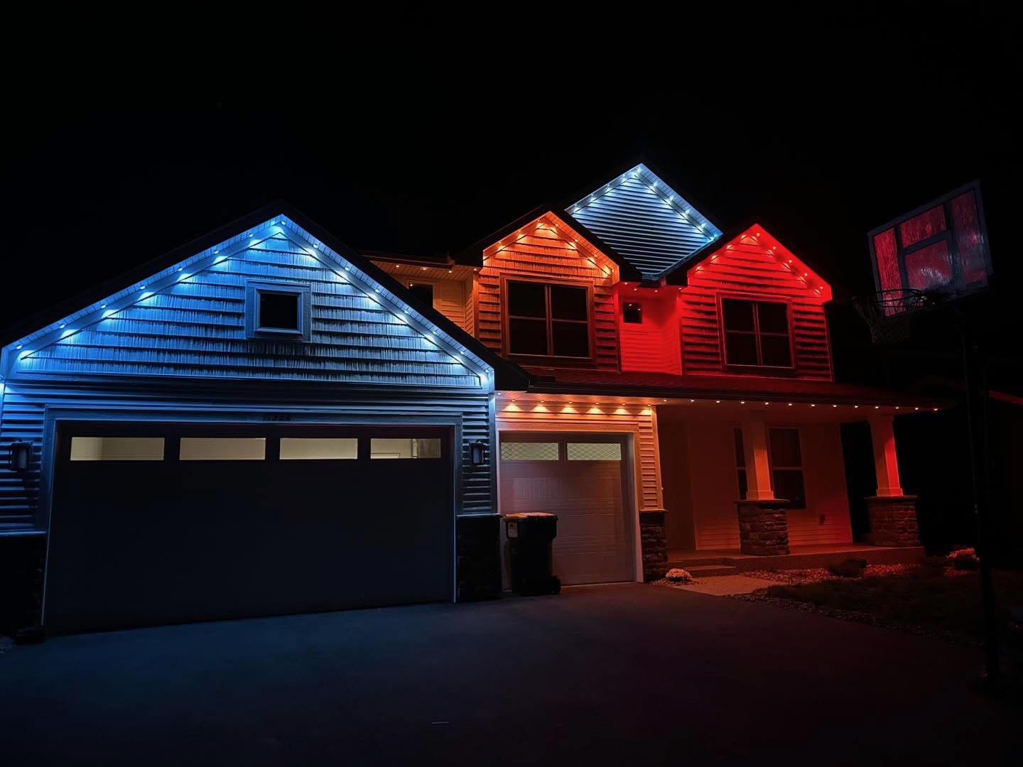 Home with blue, warm white and red permanent LED roofline lighting